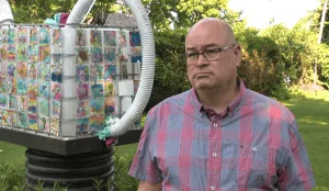 Le maire Michel Bourdeau apparaît devant une sculpture ornée de dessins d’enfants